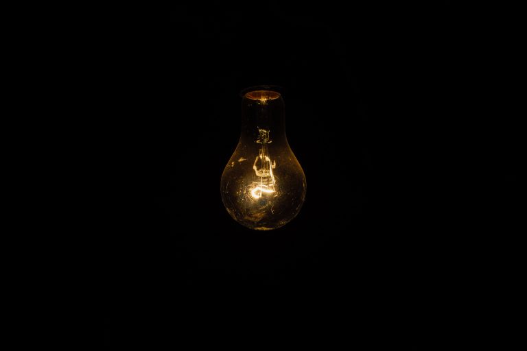 Light bulb hanging from the ceiling in a dark room